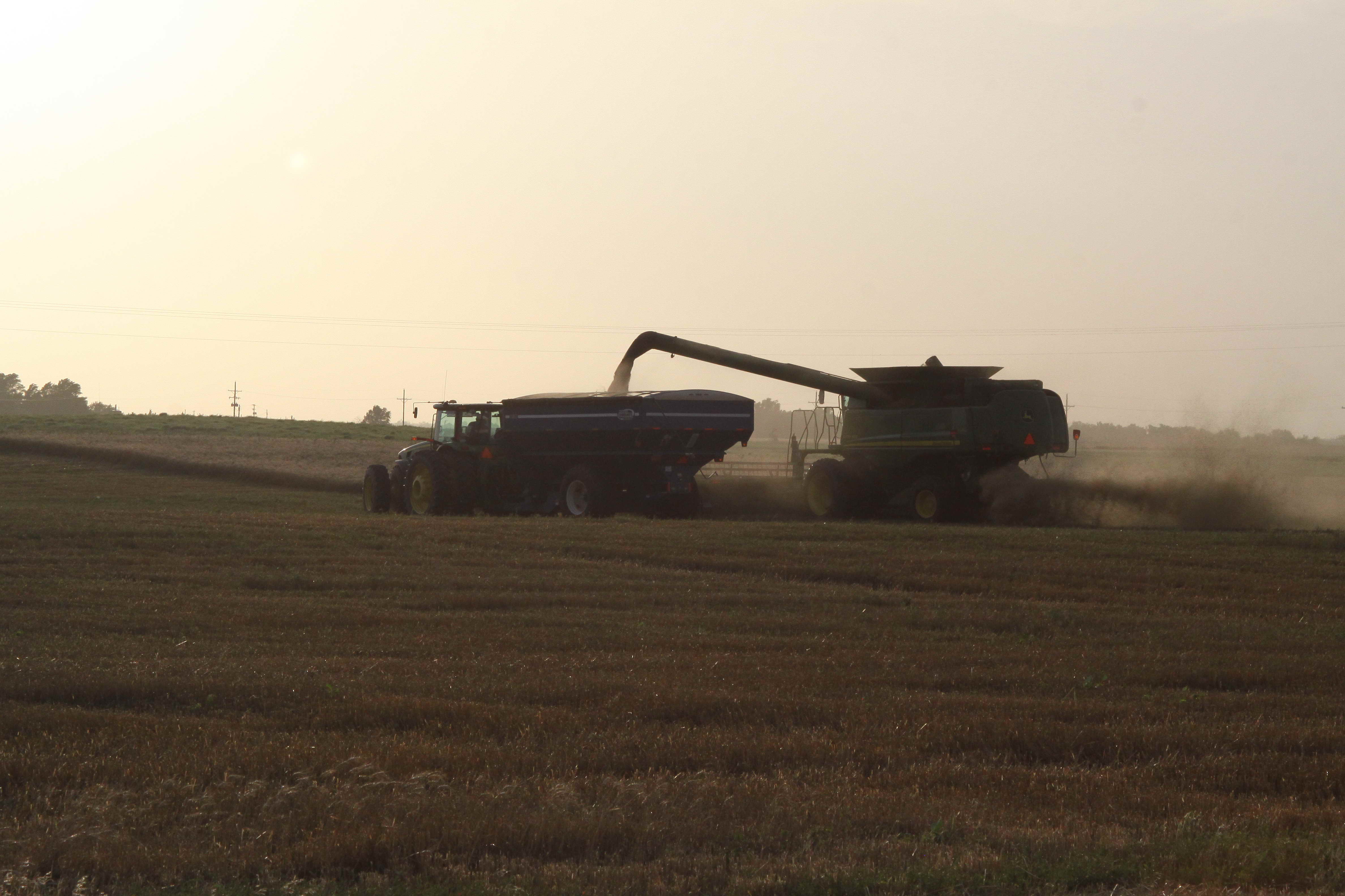 Wheat Harvest Tractor with grain bin and combine during wheat harvest